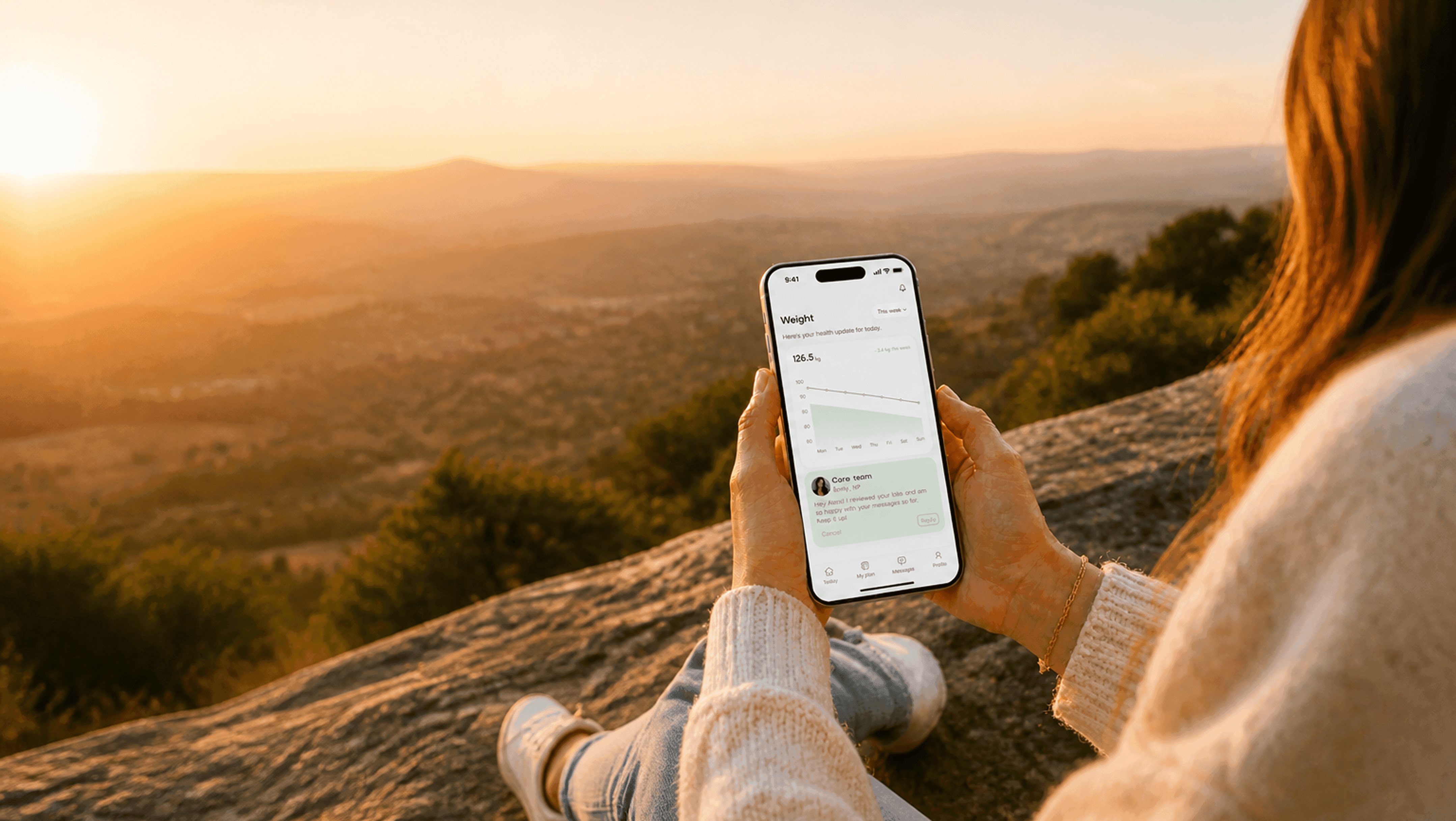 Woman checking the Auria app outdoors at sunset