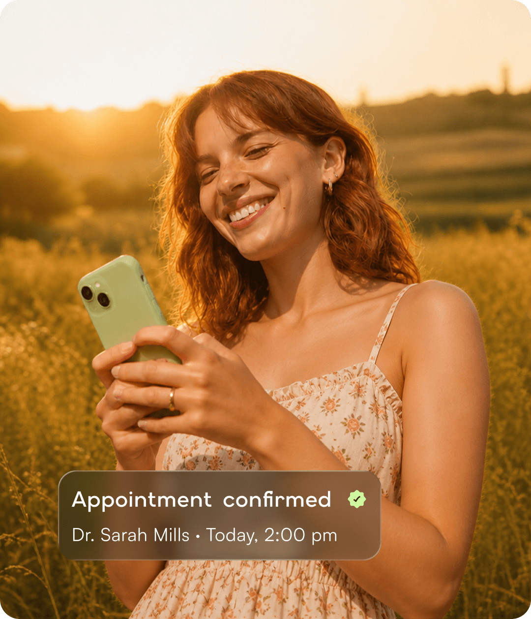 Smiling woman using her phone in a sunny meadow